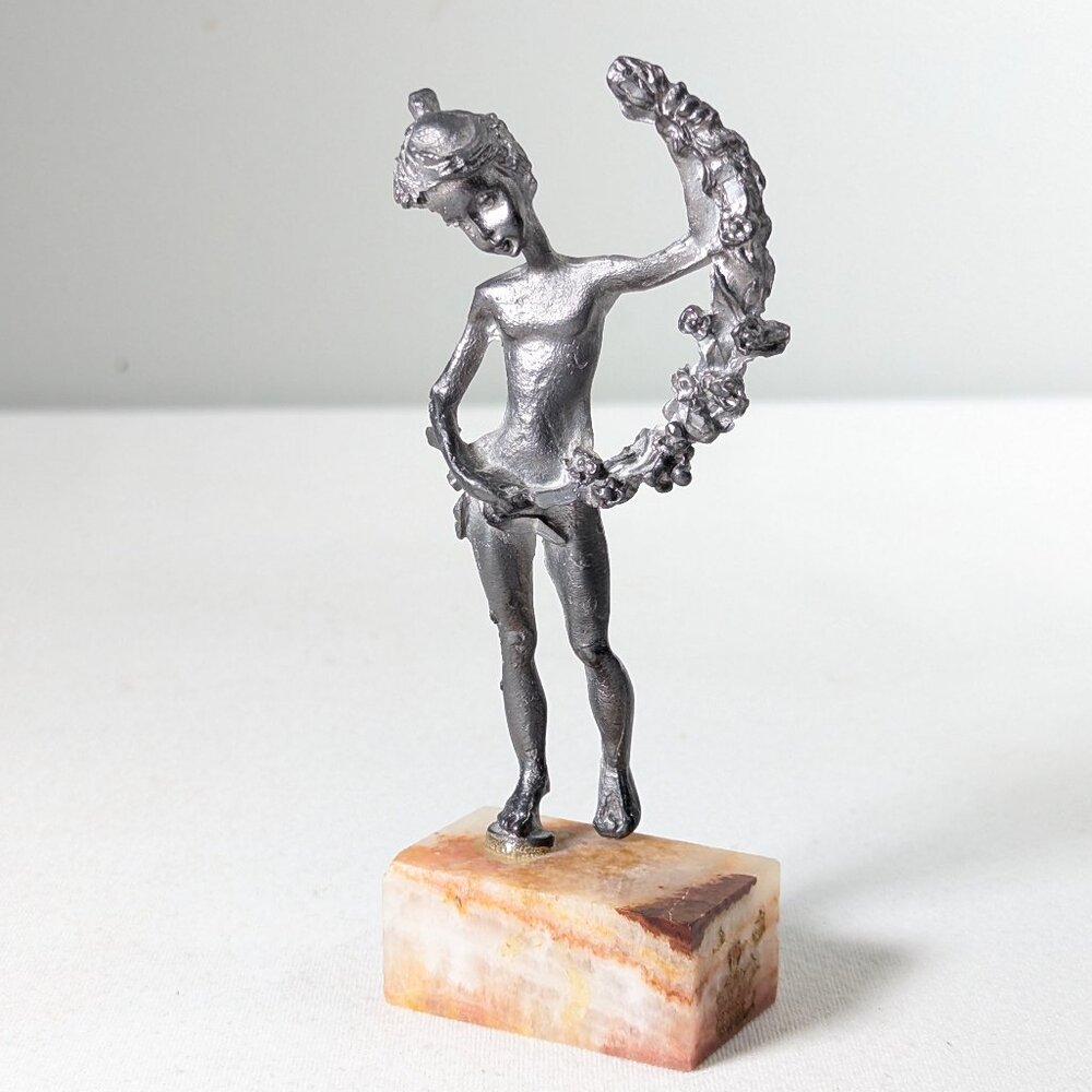 Pewter art figurine of a girl holding a wreath